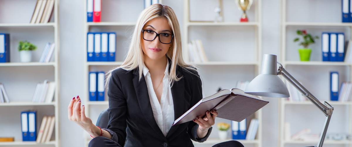 a woman in a suit holding a book, feeling very relaxed at work showing Practical Spirituality: Daily Rituals for a More Purposeful Life